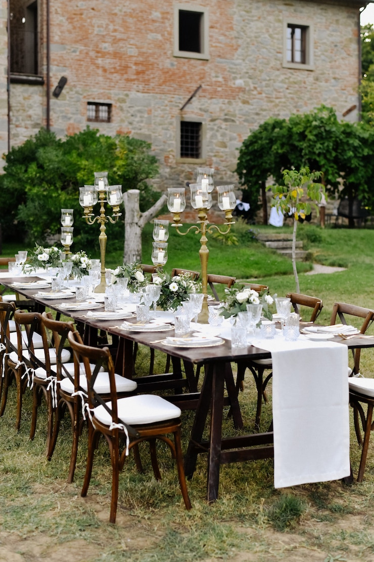 Foto grátis mesa de festa de casamento decorada com assentos de convidados ao ar livre em frente ao prédio antigo de pedra