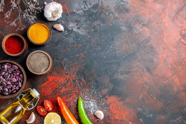 Foto grátis mesa de jantar grãos de garrafa de óleo caídos e especiarias diferentes na mesa de cores diferentes