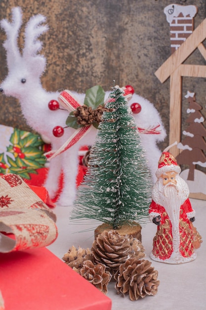 Mesa de Natal com veado de brinquedo, pinheiro e Papai Noel.