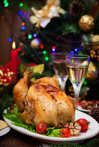 Mesa de Natal servida com um peru, decorado com enfeites e velas brilhantes