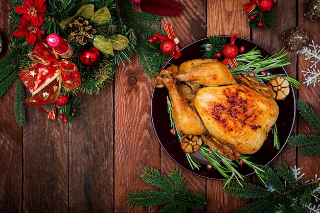 Mesa de natal servida com um peru, decorado com enfeites e velas brilhantes