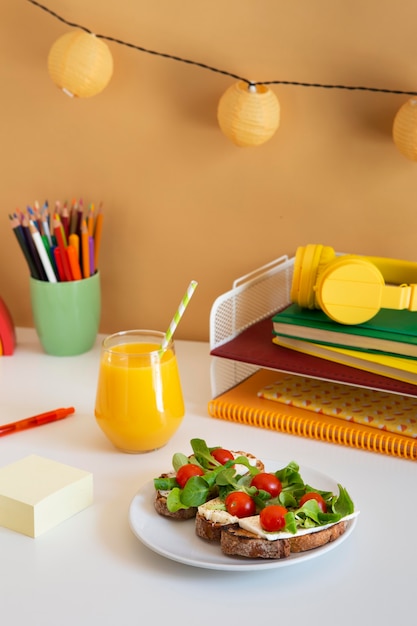 Mesa infantil em ângulo alto com sanduíches e suco de laranja