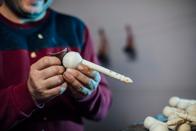 Mestre descascando figuras de madeira. Foto de alta qualidade