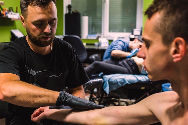 Foto grátis mestre fazendo tatuagem no estúdio