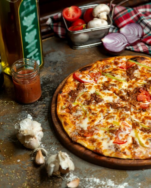 Metade da pizza de carne com pimentão de tomate e queijo