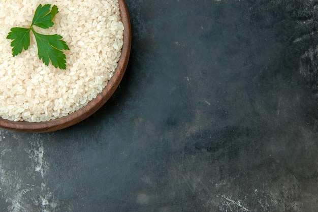 Foto grátis metade do arroz redondo perfeito em uma tigela marrom com verde no lado direito sobre fundo cinza