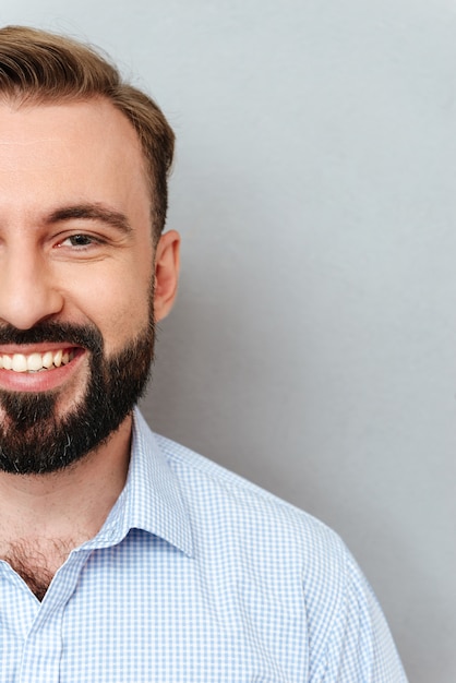 Metade do rosto do homem barbudo sorridente em roupas de negócios