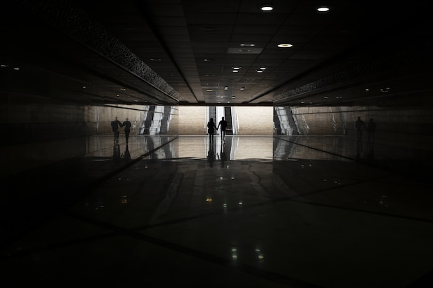 Metrô escuro com pessoas andando à distância