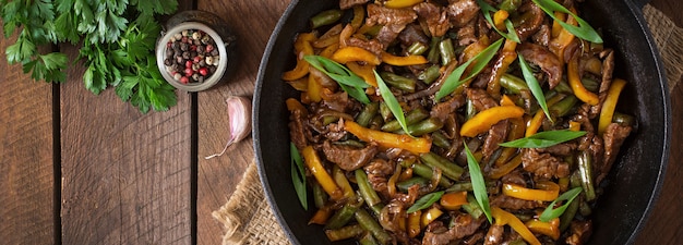 Mexa fritar carne com pimentão e feijão verde