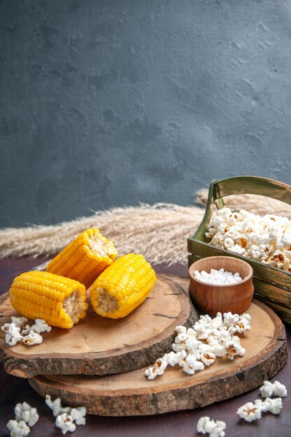 Milhos amarelos cortados com pipoca na mesa escura de mesa de lanche de milho óleo de árvore