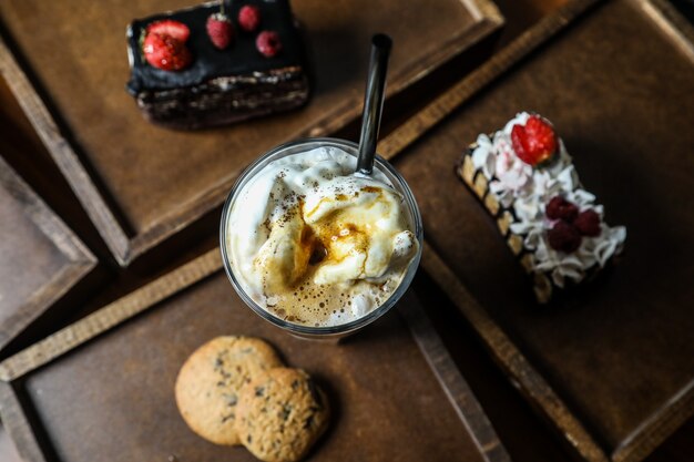 Milk-shake de vista superior com cappuccino em um copo com biscoitos em uma bandeja