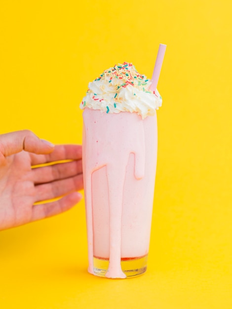 Foto grátis milk-shake rosa com fundo amarelo