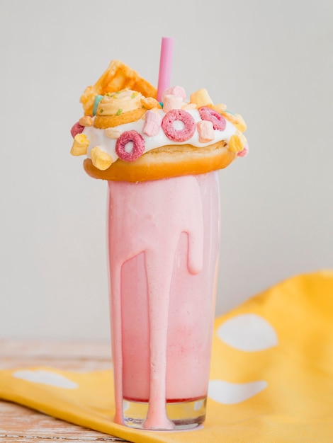 Foto grátis milk-shake rosa delicioso com rosquinha