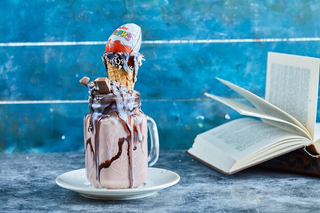 Milkshake de chocolate com barra de chocolate, surpresa gentil, casquinha de sorvete no prato branco