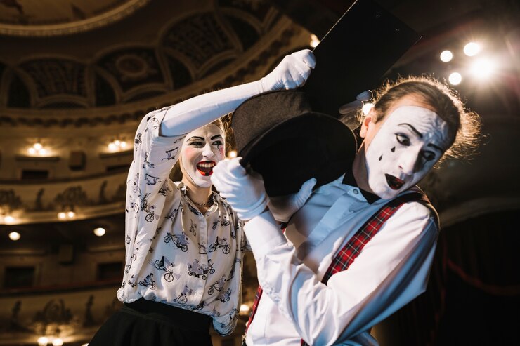 Foto grátis mime masculino com medo defendendo de mime feminino batendo com prancheta