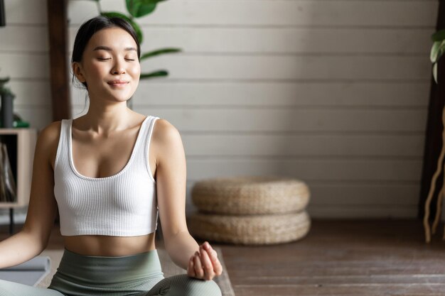 Mindfulness e meditação conceito jovem mulher asiática fazendo exercícios em casa ioga meditação na vida.