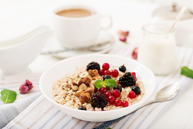 Mingau de aveia saboroso e saudável com frutas, sementes de linho e nozes. Café da manhã saudável. Comida de fitness. Nutrição apropriada.