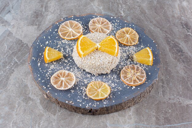 Foto grátis mingau de aveia saudável com fatias de laranja em uma peça de madeira.