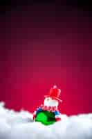 Foto grátis mini boneco de neve de vista frontal em fundo vermelho escuro