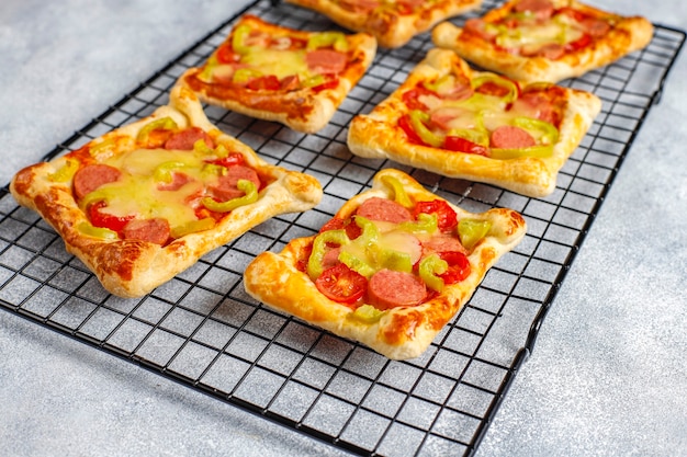 Mini pizzas de massa folhada com enchidos.