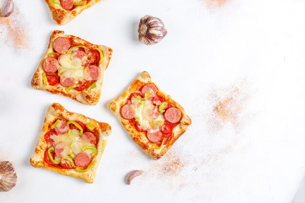 Mini pizzas de massa folhada com enchidos.