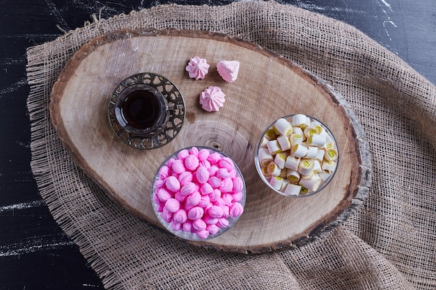 Foto grátis mistura de doces servida com um copo de chá.