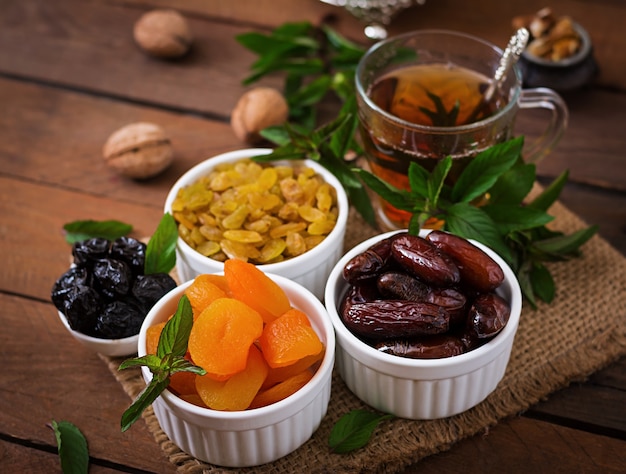 Foto grátis misture frutas secas (tâmaras, ameixas, damascos, passas) e nozes e chá árabe tradicional. comida do ramadã (ramazan).