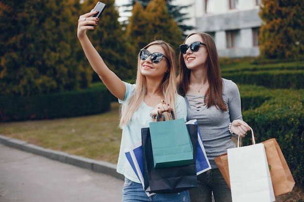 Miúdas giras com sacola de compras em uma cidade