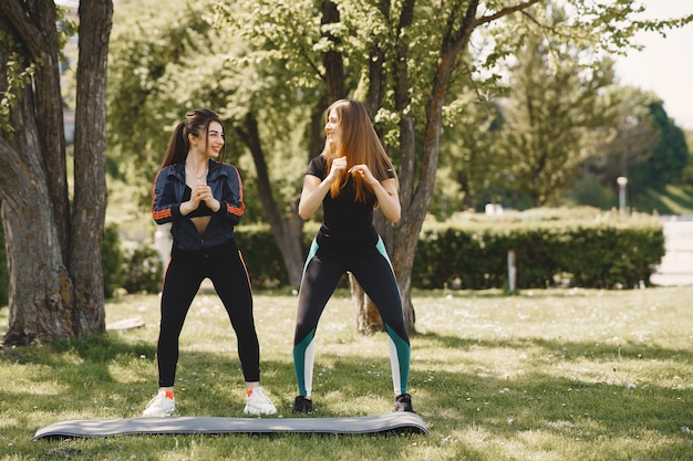 Miúdas giras fazendo yoga em um parque de verão