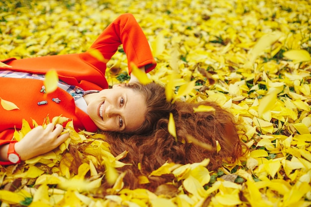 Moça bonita cercada folhas de outono