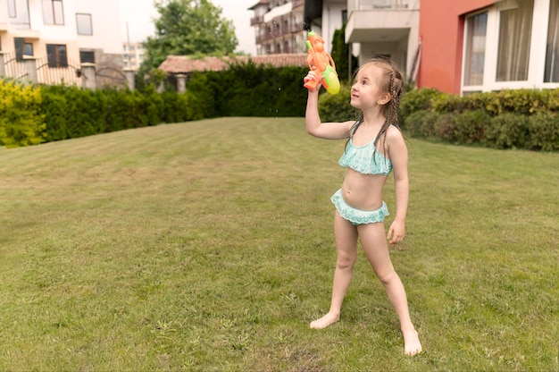 Foto grátis moça com pistola de água