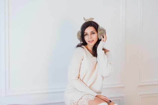 Moça de vestido branco, posando no quarto