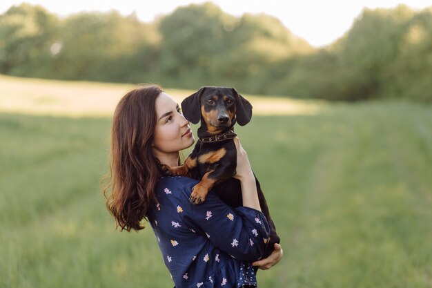 Moça em uma caminhada com seu filhote de cachorro