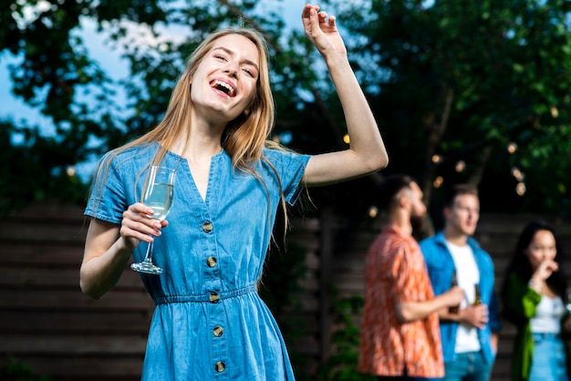 Foto grátis moça feliz que guarda o vidro de champanhe