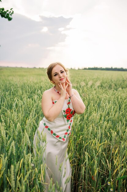 Foto grátis moça no vestido nacional ucraniano posou no campo de grinalda