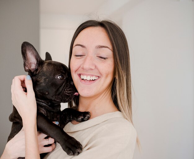 Moça sorridente segurando seu cachorro