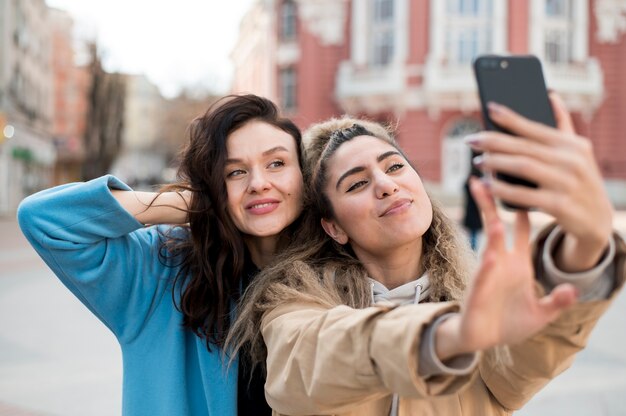 Moças bonitas que tomam um selfie junto