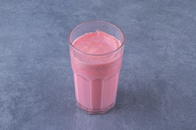 Mocha latte rosa com leite em um copo, na mesa de mármore