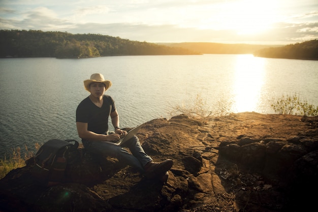 Foto grátis mochileiro relaxar na montanha com o uso de laptop