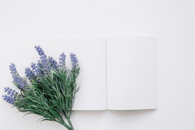 Foto grátis mockup de capa de livro com flor à esquerda