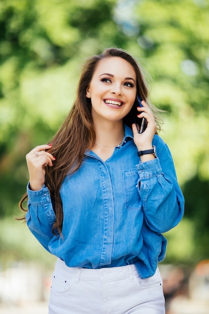 Foto grátis moda e mulher sexy caminhando e falando ao celular em uma rua da cidade