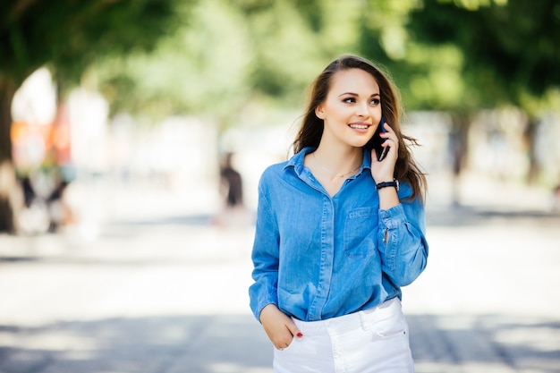 Moda e mulher sexy caminhando e falando ao celular em uma rua da cidade