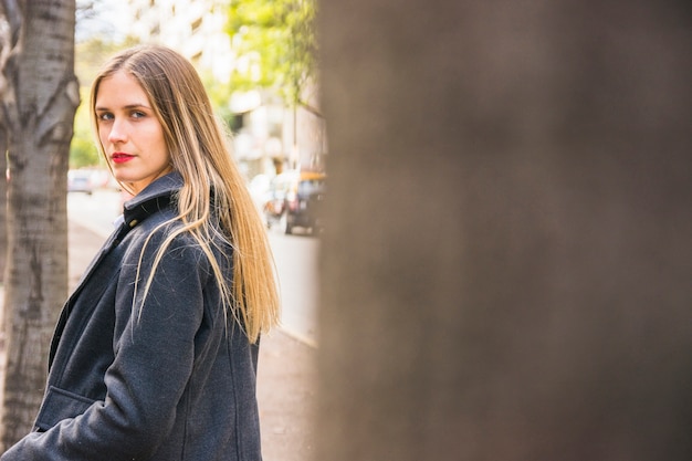 Moda jovem vestida de mulher em pé na rua urbana