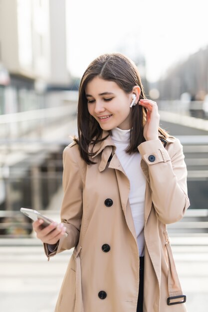 Modelo bonito colocar seus fones de ouvido sem fio durante a chamada de vídeo