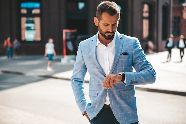 Modelo de empresário de moda bonito vestido elegante terno azul posando na rua