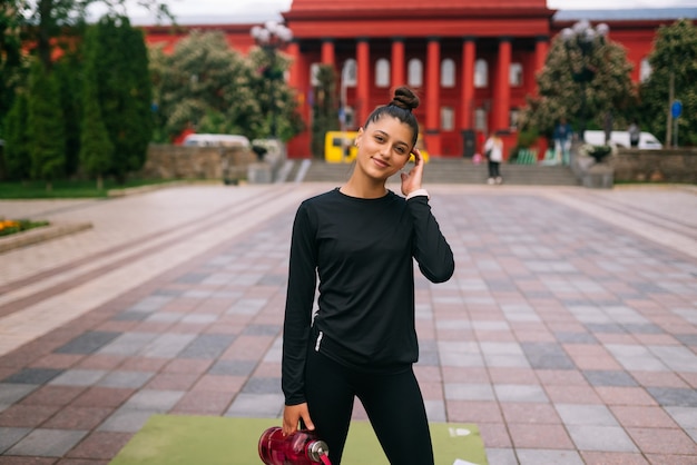 Modelo de fitness em roupas esportivas posando na rua da cidade