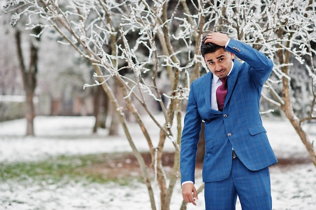 Modelo de homem elegante indiano elegante em terno posado no dia de inverno