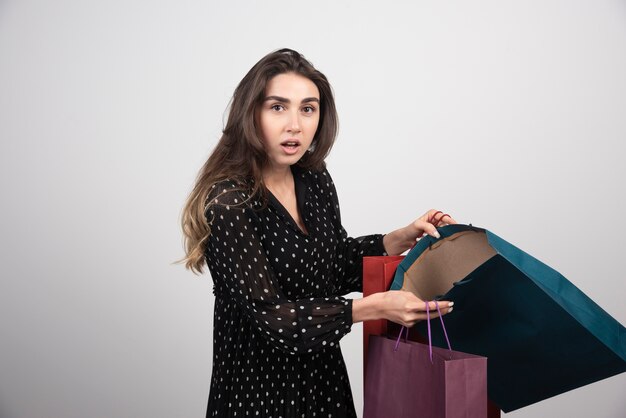 Modelo de jovem carregando muitas sacolas de compras