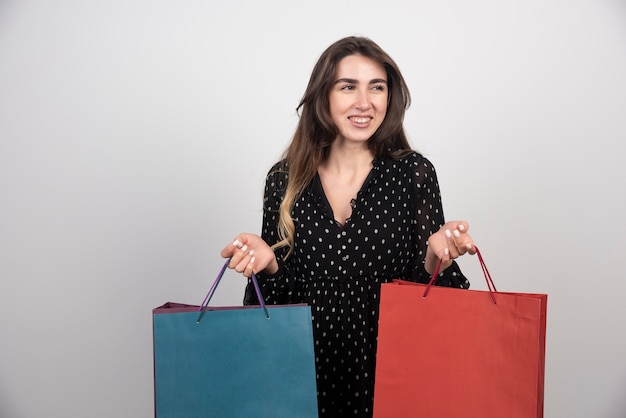 Modelo de jovem carregando muitas sacolas de compras