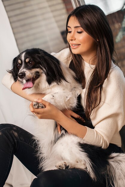 Modelo de moda em camisa branca com cachorro branco preto